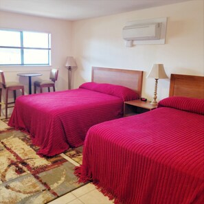 A hotel room with two beds, a small table, a chair, and a window. - The Lake Store Lodging Room #2 (Winnsboro)