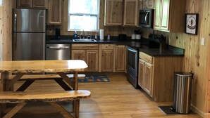 A kitchen with wooden cabinets, a stainless steel refrigerator, a microwave, and a sink. - Welcome to Mountain Momma (Mount nebo)