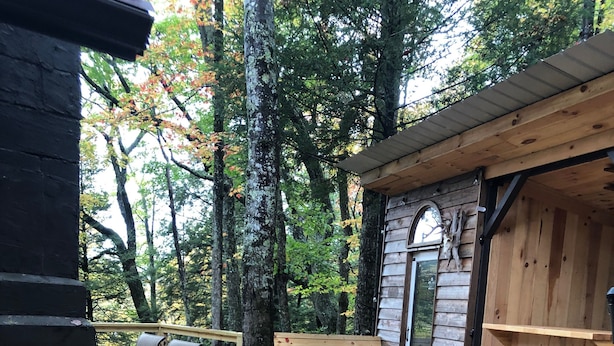 A wooden deck with a grill, seating, and a small building with a door and shelves. - Welcome to Mountain Momma (Mount nebo)