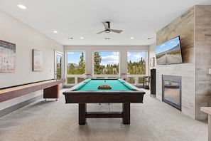 A pool table with a view of trees and mountains, a ceiling fan, and a fireplace. - Luxury|Views|Hot Tub|Free Bus Route (Breckenridge)