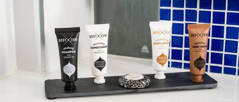 Vier Body Zone producten op een zwarte dienblad.