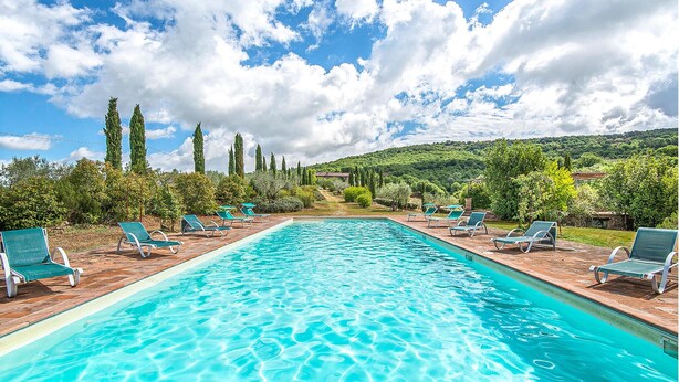 Ein rechteckiger Pool mit klarem, blauem Wasser, umgeben von einer Holzterrasse.