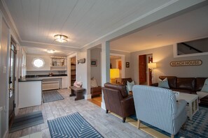 A spacious living room with a fireplace, a dining area, and a kitchen.