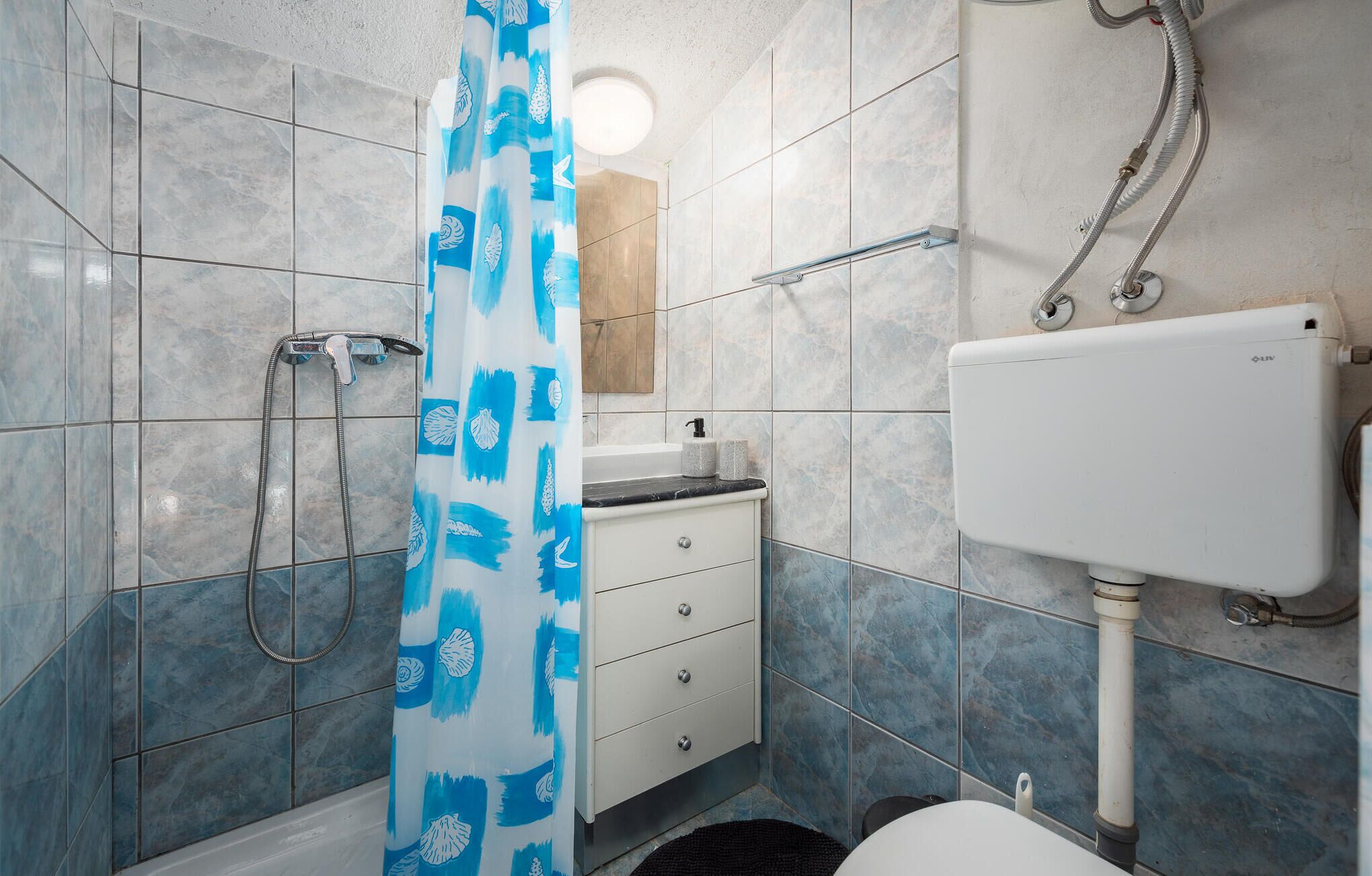 A bathroom with a shower, toilet, and sink.