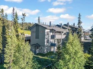 A multi-story residential building with a stone foundation, surrounded by dense forest. - Rukatonttu d 14 by Interhome (Kuusamo)