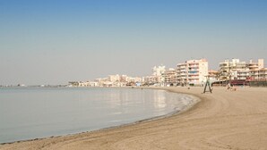 A beach with a row of multi-story buildings in the background. - Cozy apartment in Santa Pola with WiFi (Santa Pola)