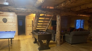 A cozy indoor space with a foosball table, a ping pong table, and a couch. - Rustic Mountain Cabin (New Meadows)