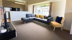 A modern living room with a sectional sofa, a small table, and a TV.
