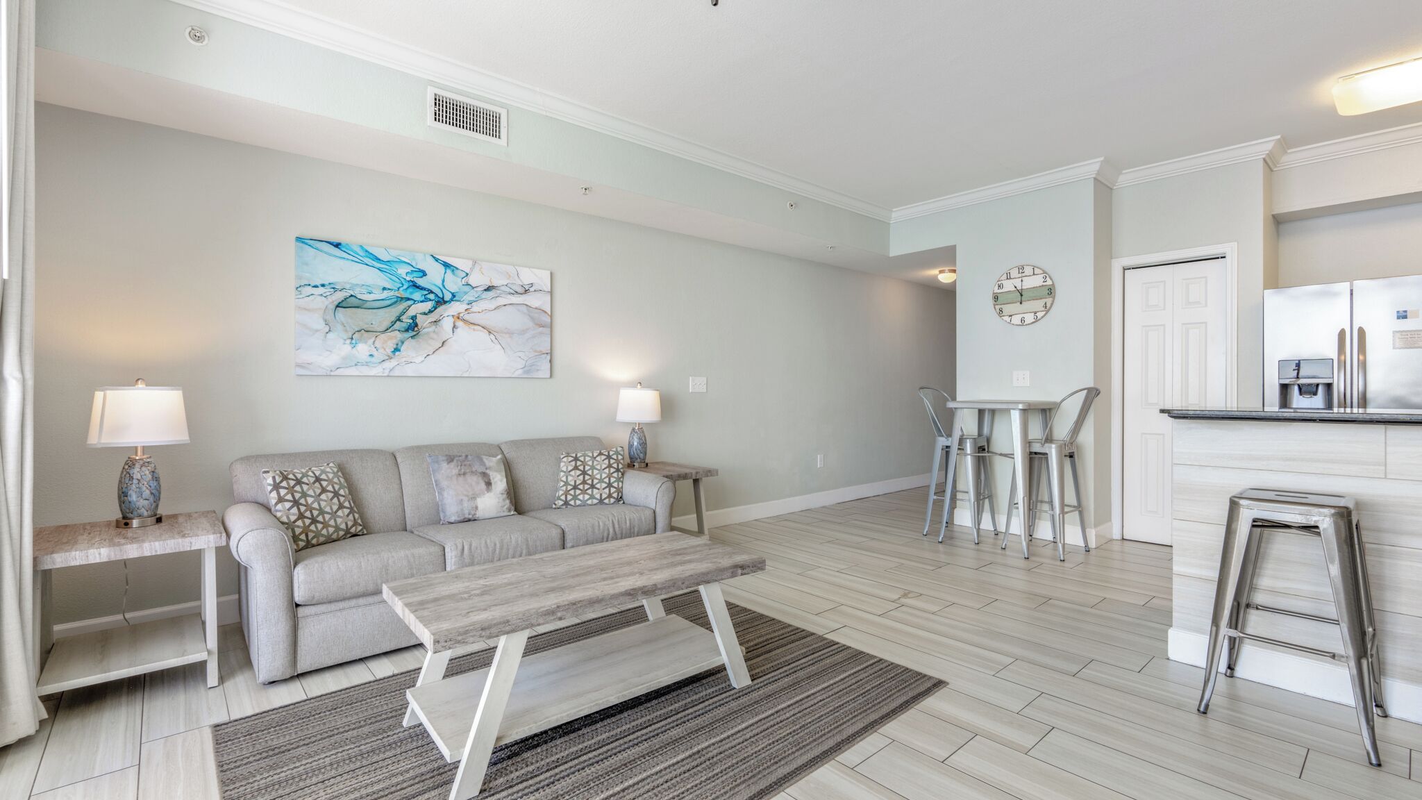 Un salon moderne avec un canapé, une table basse et un tableau accroché au mur.