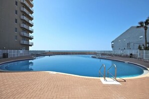 Enjoy a refreshing swim in the oval-shaped pool surrounded by a tiled deck and metal handrails.