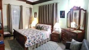 Une chambre à coucher avec un lit, une commode, une chaise et un canapé.