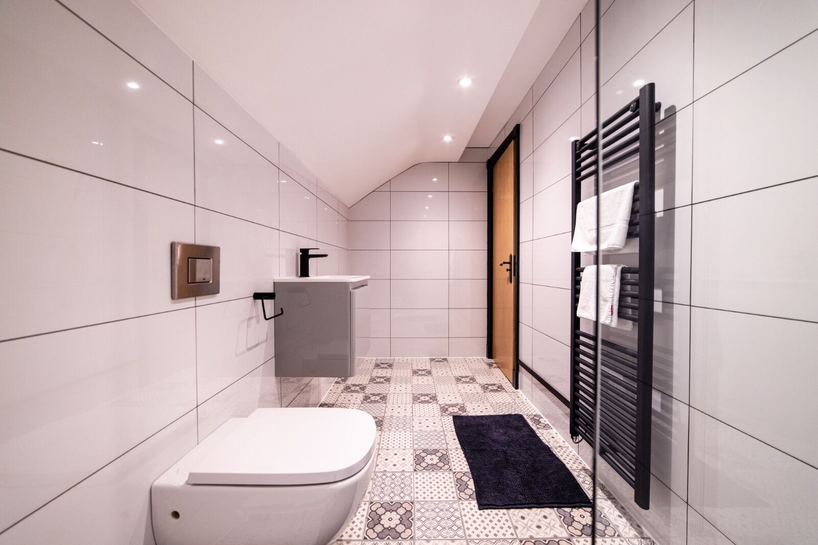 A modern bathroom with a toilet, sink, and shower area.