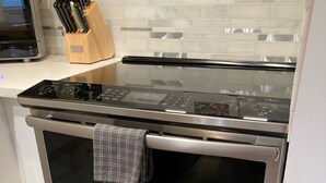 A modern kitchen with a double oven, a microwave, and a knife block on the countertop. - FIFA WORLD CUP!!! Luxury Lakefront Lake Sammamish Apartment (Redmond)