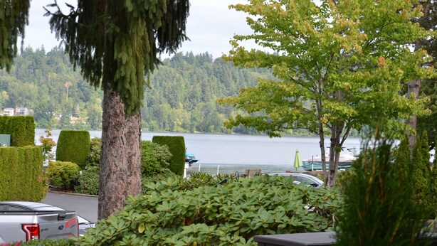 A parking area with neatly trimmed hedges and a view of a lake. - FIFA WORLD CUP!!! Luxury Lakefront Lake Sammamish Apartment (Redmond)