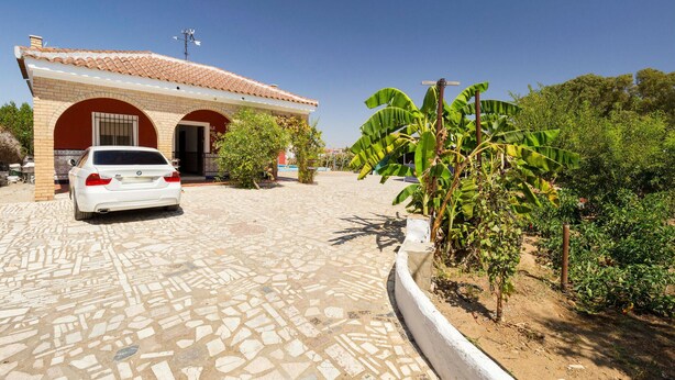A white car parked in front of a building with a tiled roof and brick walls. - Beautiful home in Olivares (Olivares)