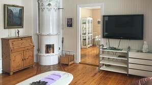 A living room with a fireplace, wooden furniture, a television, and a bookshelf. - Gorgeous home in Rörvik with WiFi (Rörvik)