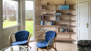 A room with two blue chairs, a bookshelf, and a door. - Gorgeous home in Rörvik with WiFi (Rörvik)