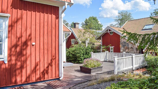 A red wooden building with a white porch and a stone wall. - Gorgeous home in Rörvik with WiFi (Rörvik)