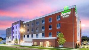 Edificio de Holiday Inn Express & Suites con fachada de ladrillo, varias ventanas y una entrada bien iluminada.