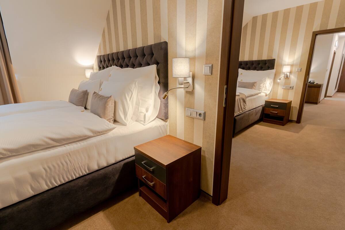 Une chambre d’hôtel avec deux lits, une table de chevet et un miroir.