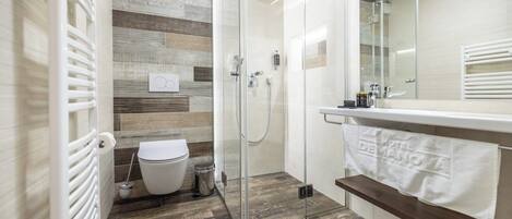 A modern bathroom with a glass-enclosed shower, a white toilet, and a wooden floor.