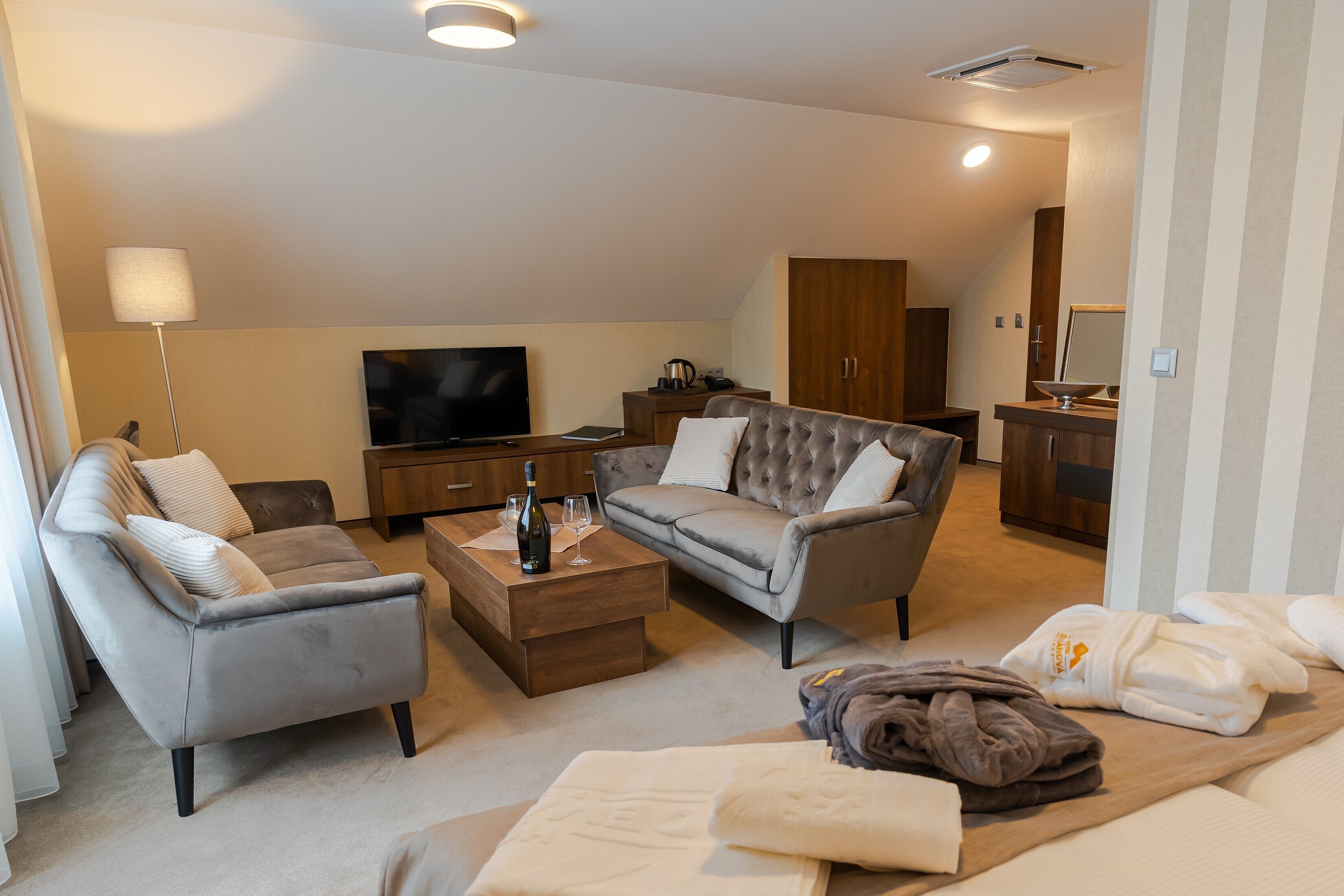 Una sala de estar moderna con un sofá gris, una mesa de centro, un televisor de pantalla plana y un mueble de madera.