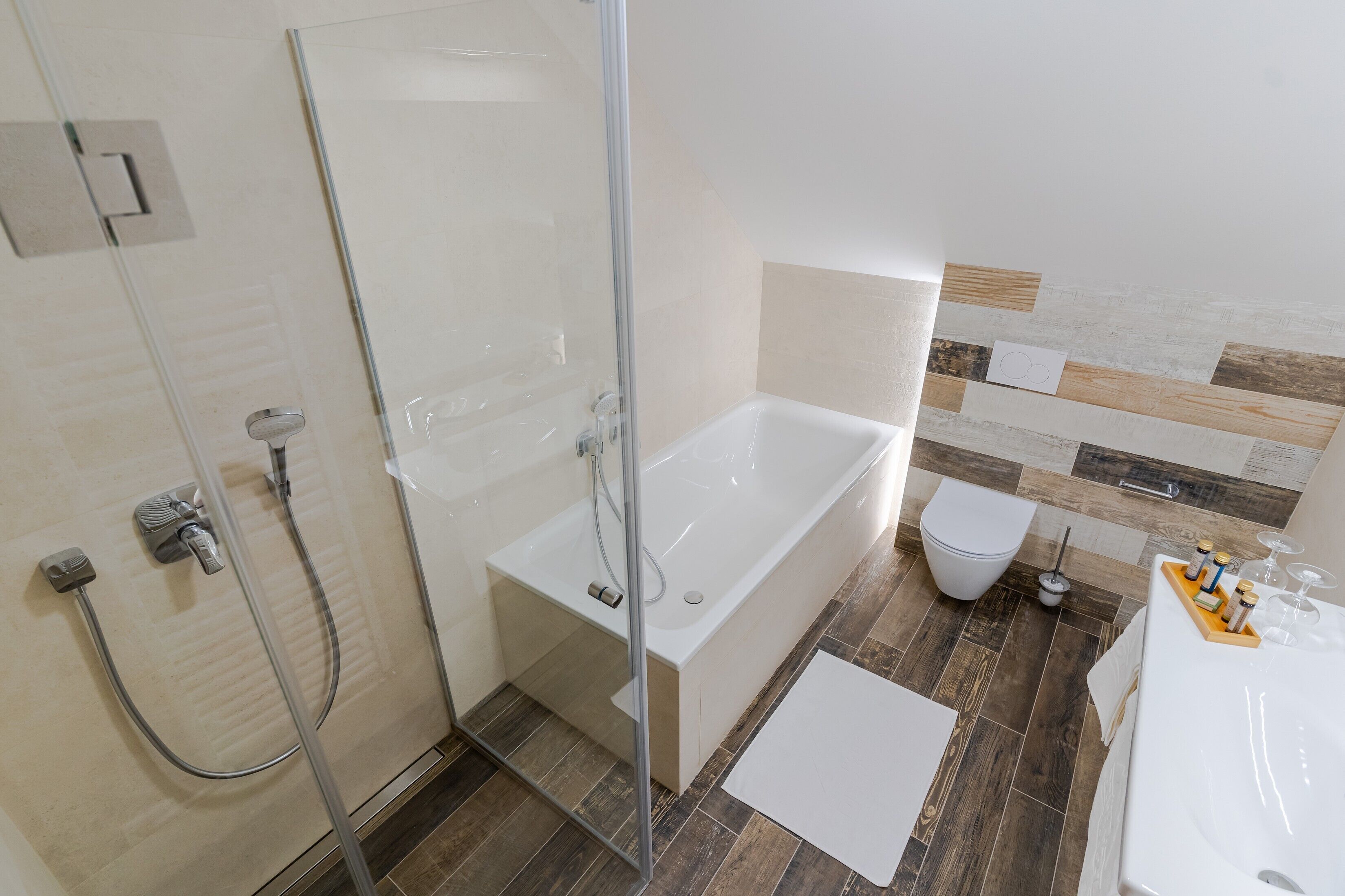 A modern bathroom with a glass-enclosed shower, a standalone bathtub, and a toilet.
