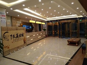 A hotel reception area with a modern design, featuring a reception desk, a digital screen, and a glass entrance. - Greentree Inn Beijing Tongzhou District Yujiawu Techonology Park Express Hotel (Tongzhou)