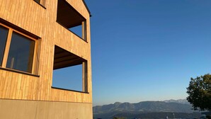Een modern gebouw met een houten gevel en meerdere ramen.