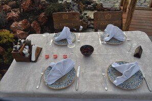 Enjoy meals al fresco at this outdoor dining area, surrounded by comfortable chairs and a beautiful natural backdrop.