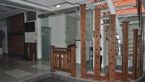 Un espace intérieur moderne avec un escalier en bois, des cloisons en verre et un sol carrelé.