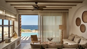 A modern living room with a sofa, a chair, a coffee table, and a view of the sea through large windows. - Lesante Cape - The Leading Hotels of the World (Zakynthos)