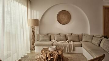 A cozy living room with a sofa, chairs, a coffee table, and a lamp.