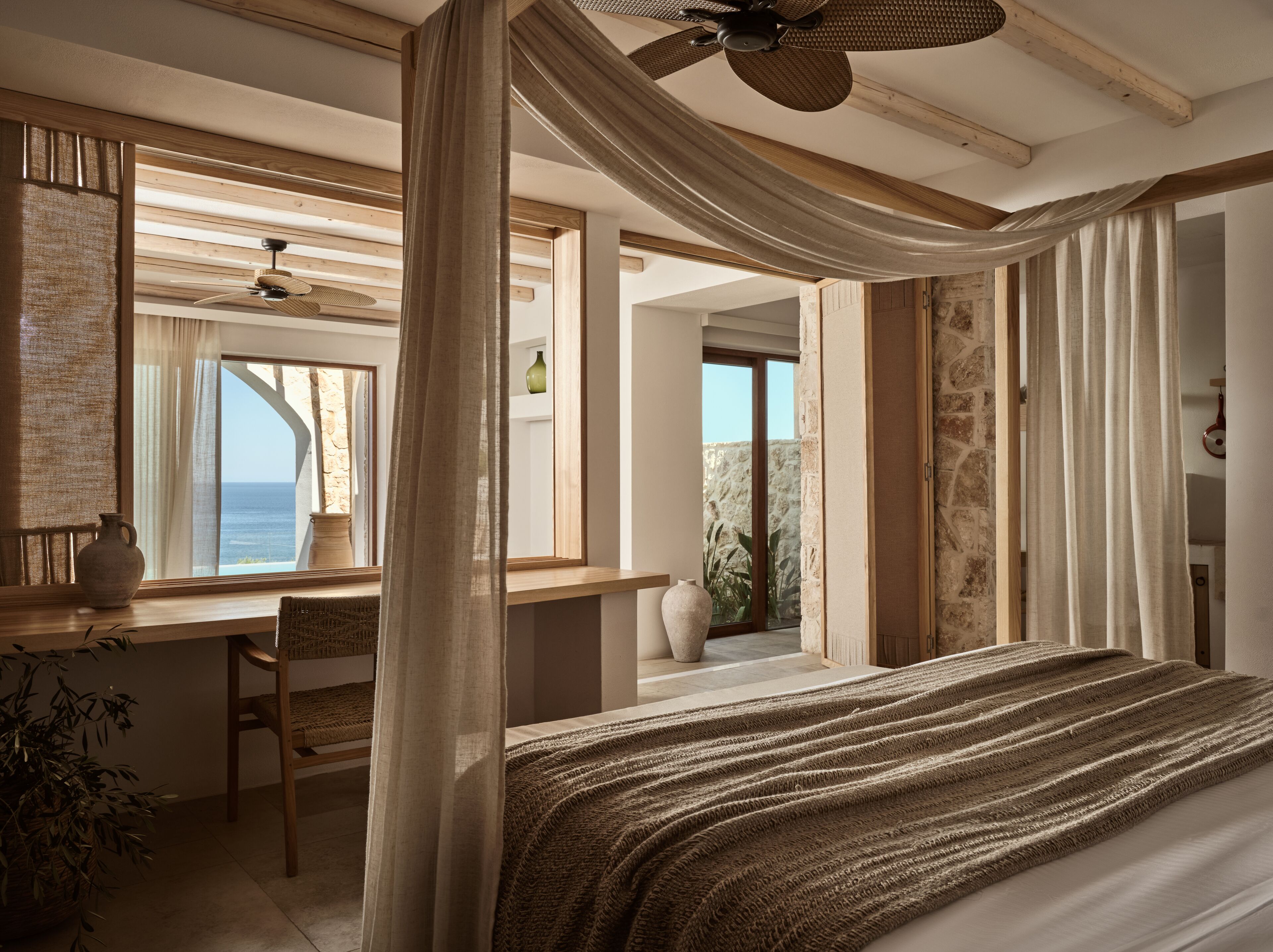 Una camera da letto con un letto grande, una scrivania e vista sul mare.