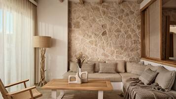 A modern living room with a stone wall, a wooden coffee table, a sofa with patterned cushions, and a floor lamp.
