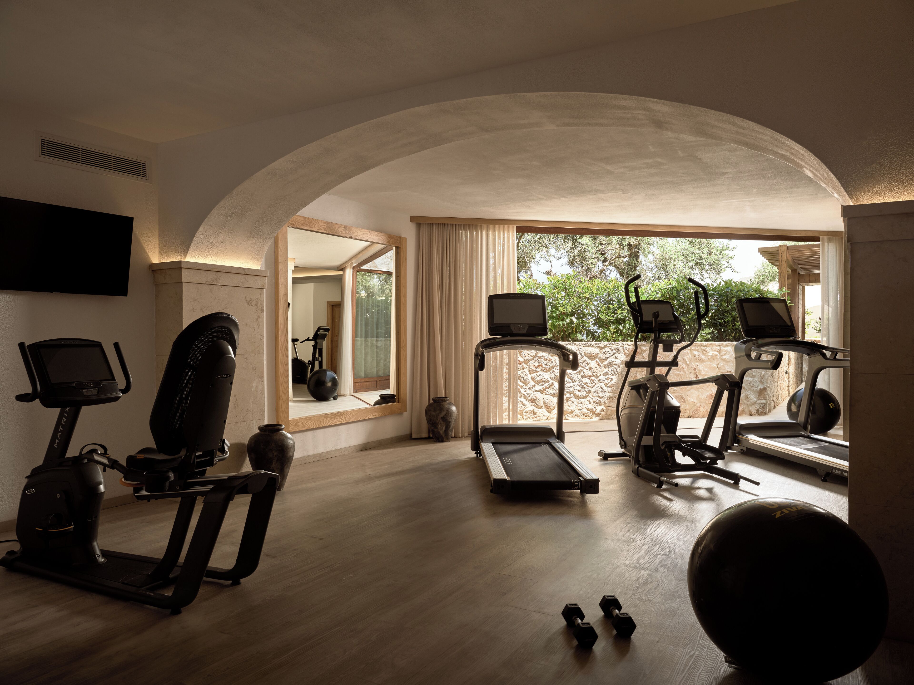 Un gimnasio en casa con cintas de correr, elípticas y mancuernas.