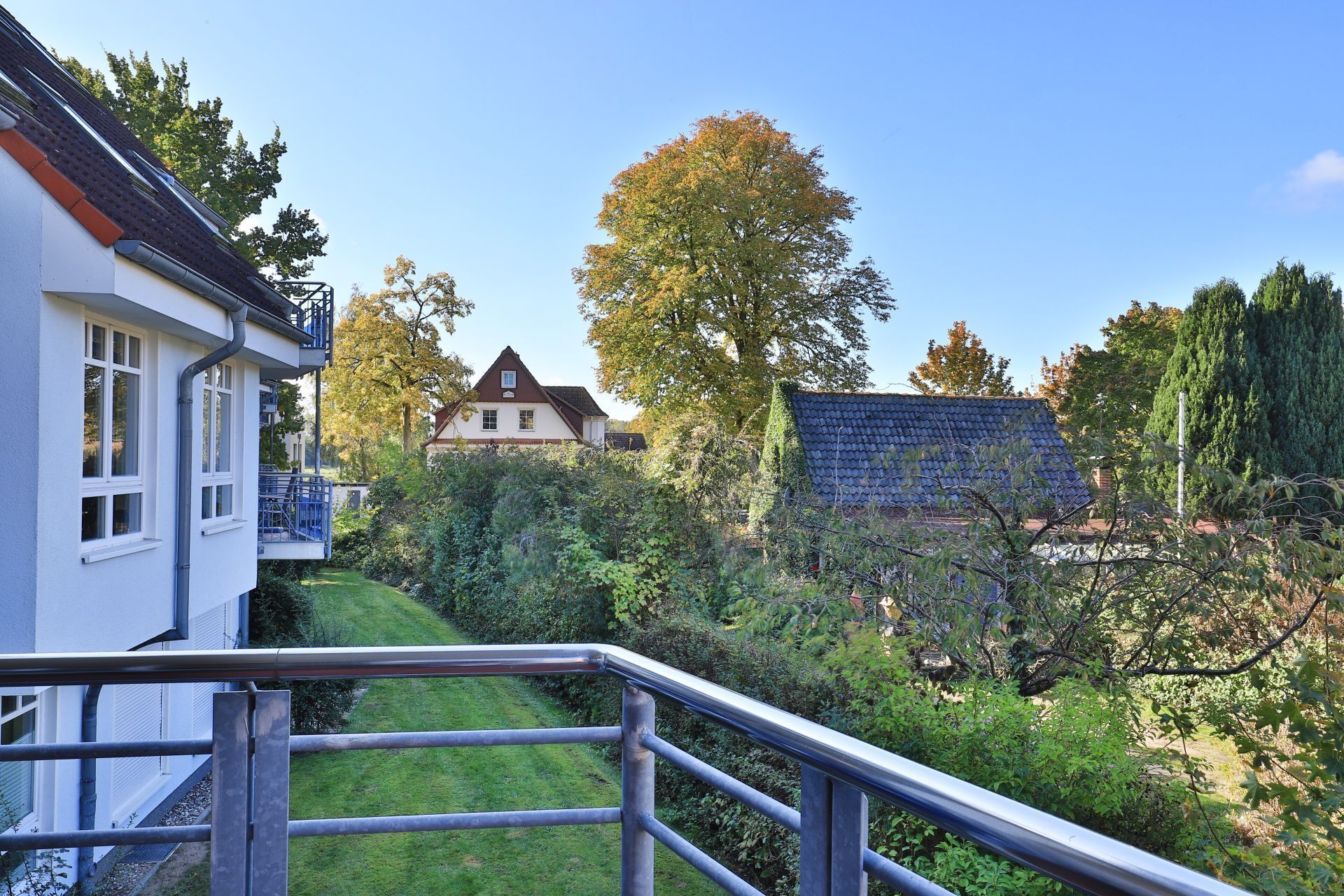 Et boligområde med et hus, et træ og en bygning med et blåt tag.