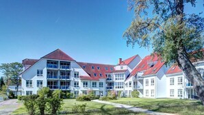 A modern building with multiple floors, large windows, and a red roof. - Likedeeler Whg. Li20 (Ostseebad Boltenhagen)