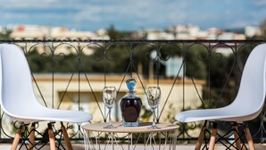 A balcony with two white chairs and a table, a bottle, and two glasses. - Thea Artemis (Chania)