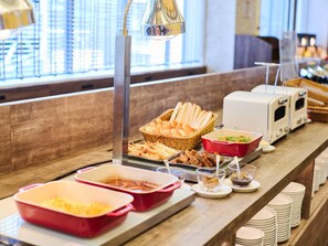 A buffet setup with various food items and serving utensils.