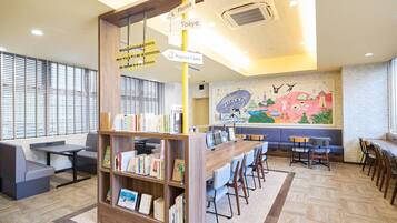 Um café em uma biblioteca, com estantes, mesas e cadeiras.
