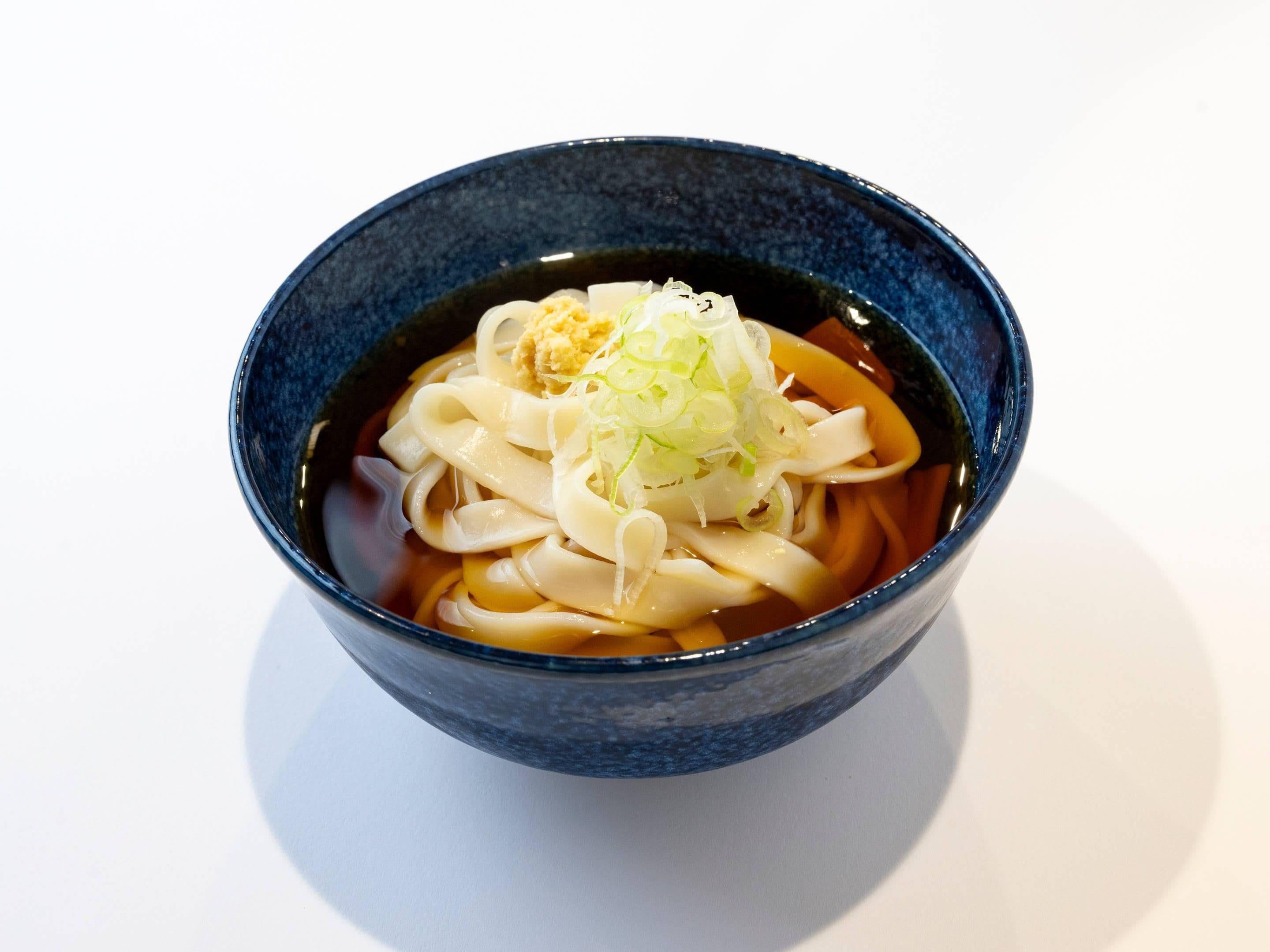 Eine Schüssel Ramen mit Nudeln, einem Belag und Brühe.