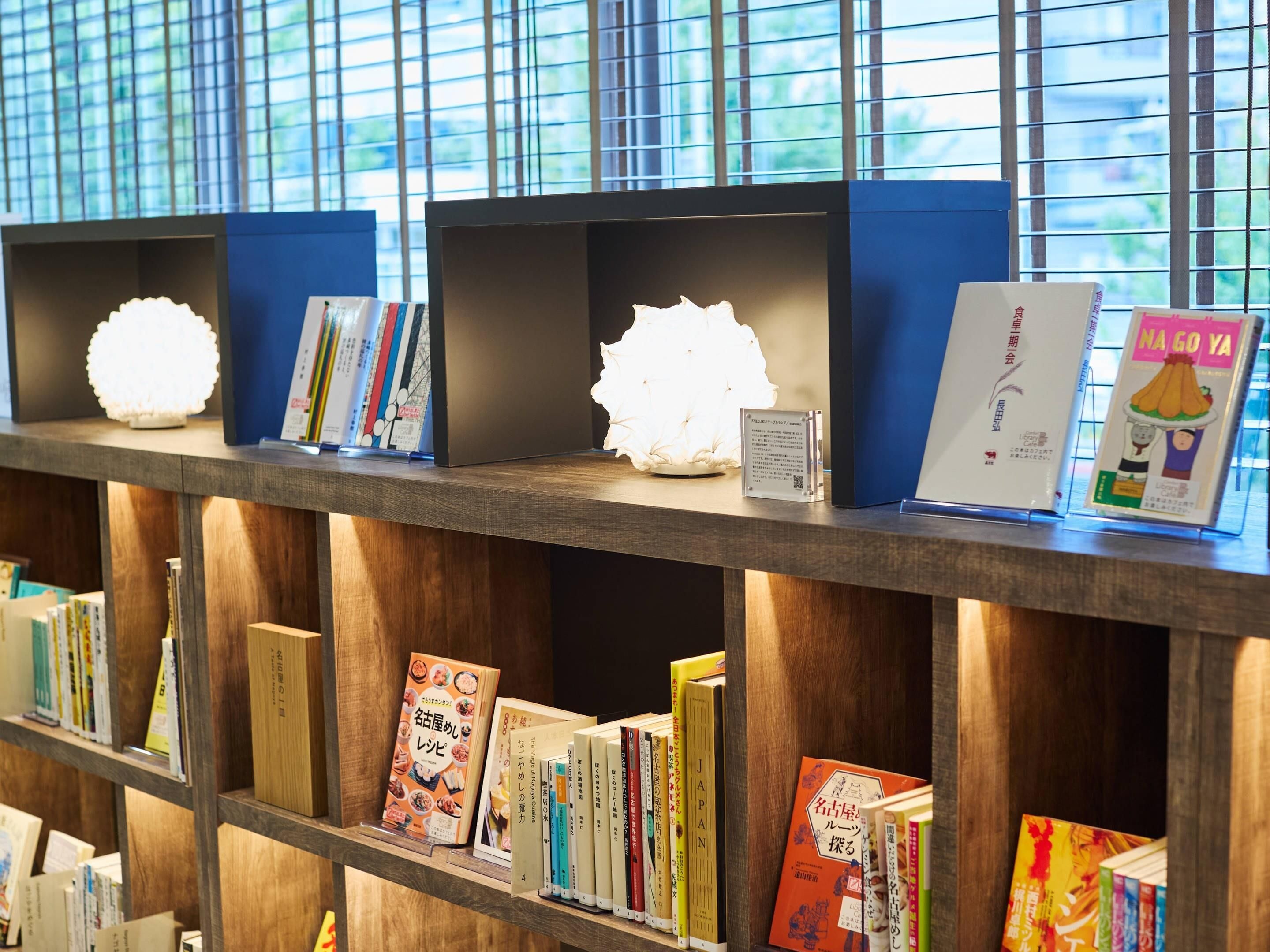 Uma estante com livros e luzes decorativas.