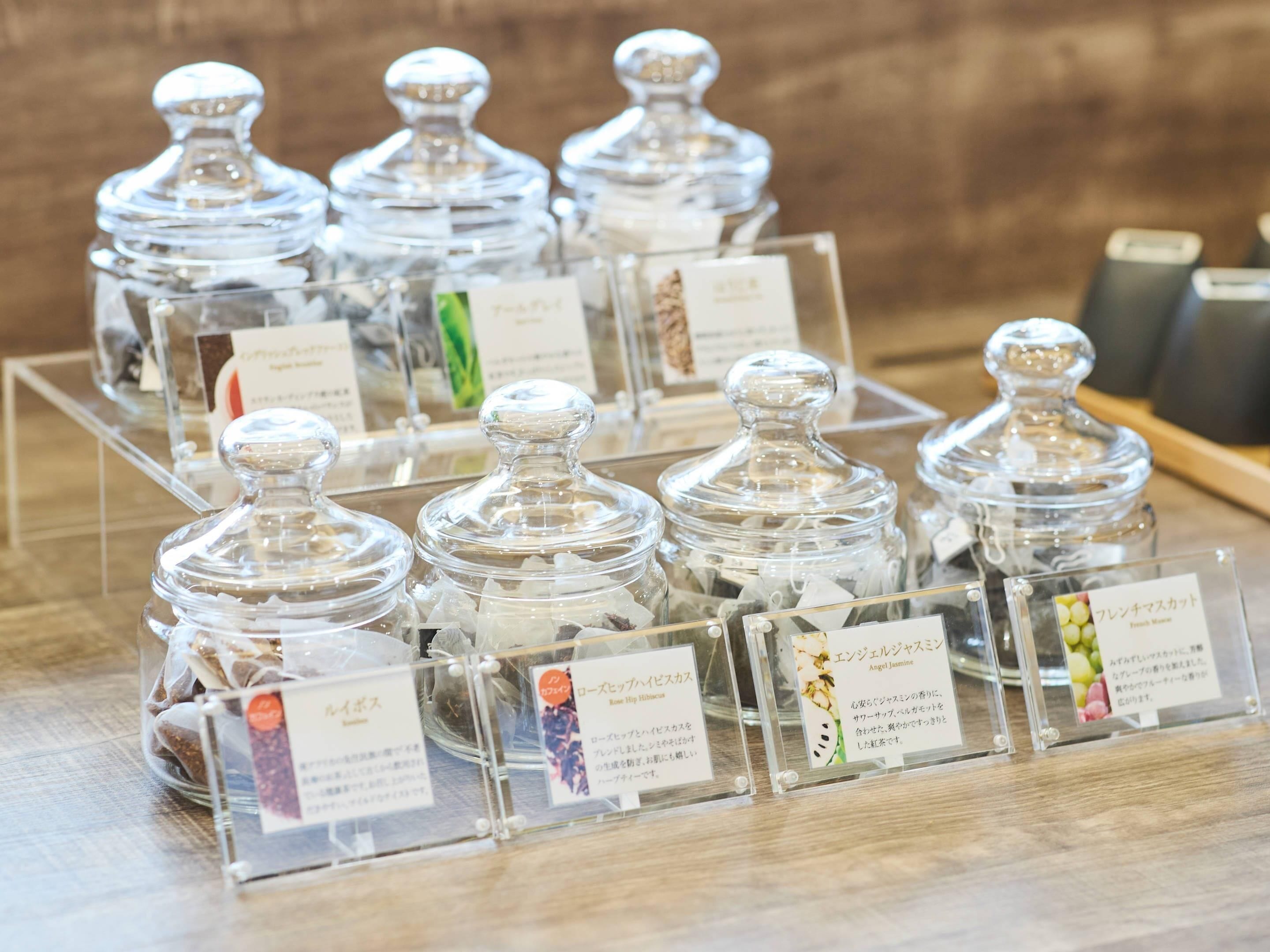 Una exhibición de recipientes de vidrio transparente con etiquetas, presumiblemente conteniendo diferentes alimentos o condimentos.