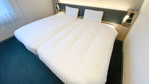 A hotel room with a large bed, two pillows, a headboard with built-in lighting, and a small bedside table. - Comfort Hotel ERA Nagoya Meiekiminami (Nagoya)