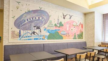 A restaurant with a mural, seating, and a brick wall.
