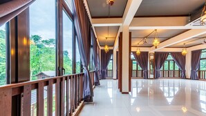 A spacious hotel room with large windows, wooden railings, and multiple hanging light fixtures. - Bentong Eco Wellness Resort (Raub)