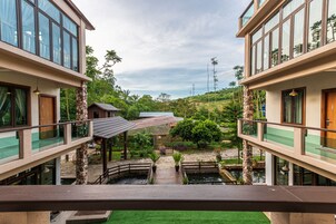 Un edificio moderno con un patio central, pilares de piedra y un pequeño puente.