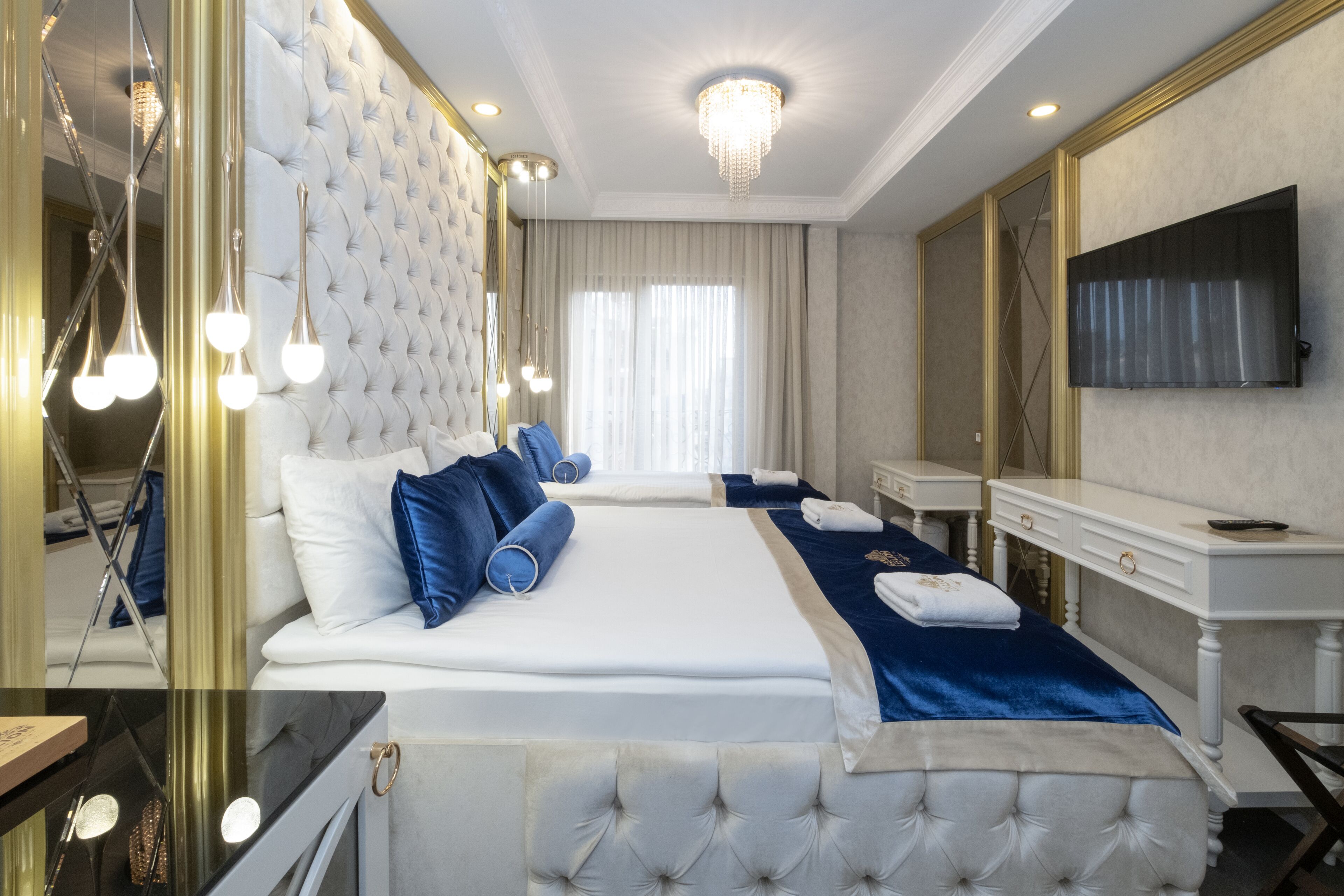 Une chambre d’hôtel avec un grand lit, une télévision, un bureau et un miroir.