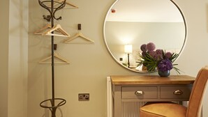 A room with a coat rack, a mirror, a wooden dresser, and a chair. - Valentinos Restaurant With Rooms (Ripon)